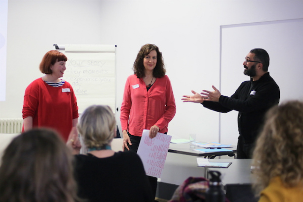 3 people standing in a group workshop in front of a whiteboard