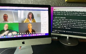 Two computer screens. One with 4 people ina ZOOM call and the other with a transcript of what is being said.