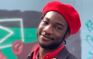 Samuel Remi-Akinwale is a young black man. In this photo he is looking into camera and smiling, wearing a red beret