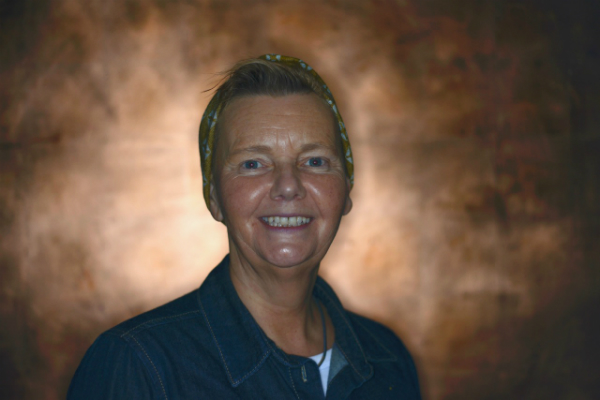 Jackie Driver in headscarf against a golden background