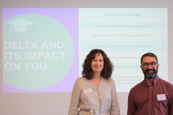 Jane and Hormoz in front of a projected slide which reads 'Delta and its impact on you'